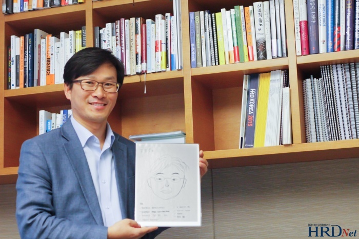 김진용 CJ 인재원 상무가 리더십 팀원이 그려준 사진을 들고 있다.